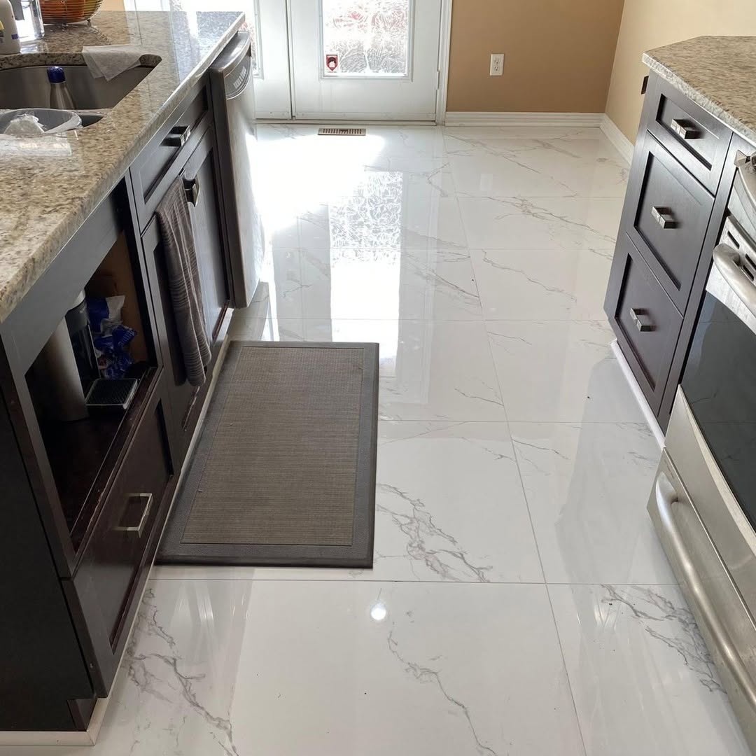 Galley kitchen with marble-look porcelain tile floor and granite counters