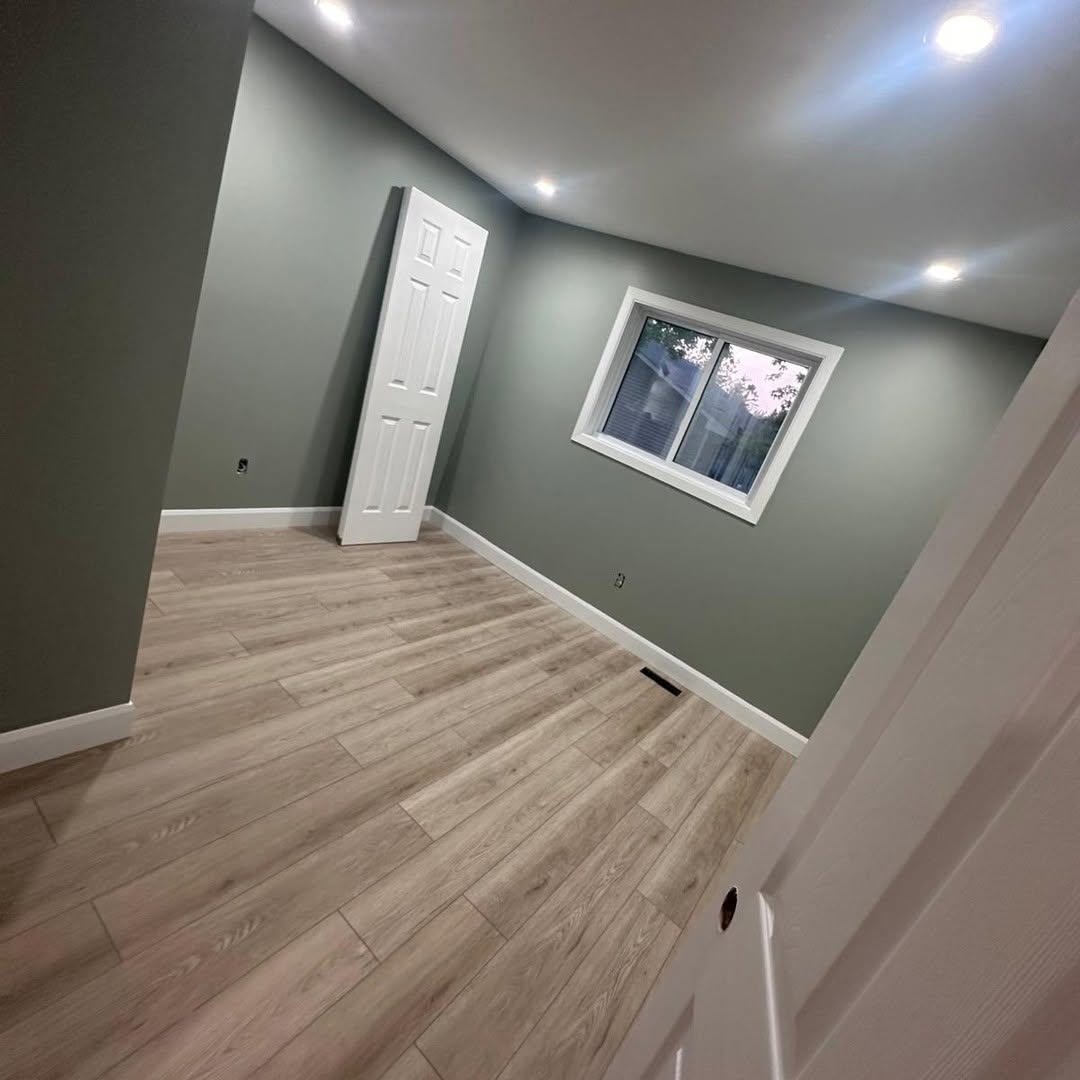 Basement bedroom painted sage green with new laminate flooring